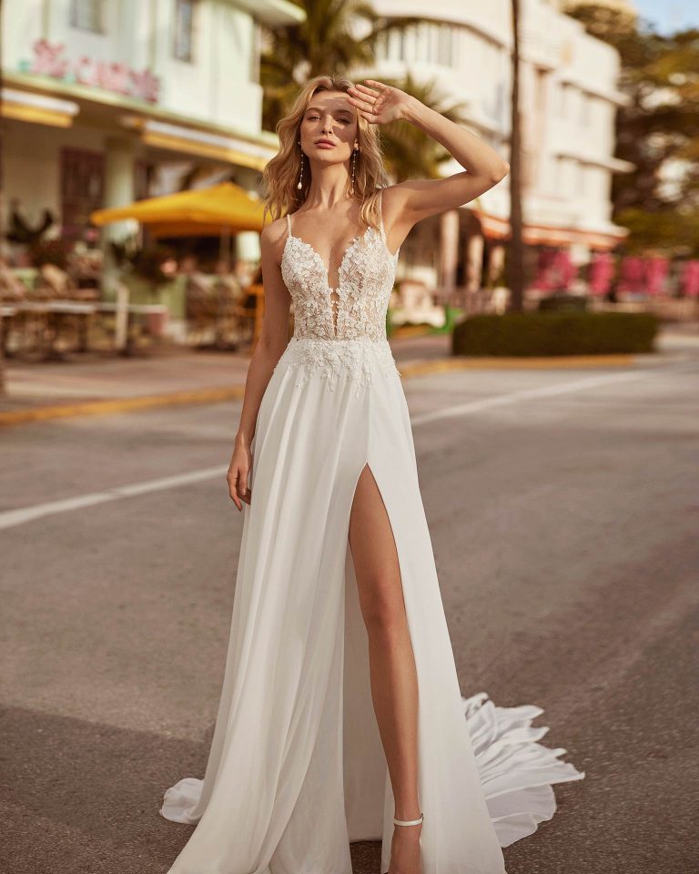 Sexy A-line wedding dress, crafted in georgette. Featuring a V-neckline, open back, straps and skirt with a front slit. Get the perfect look in this delicate Luna Novias design. LUNA_NOVIAS.