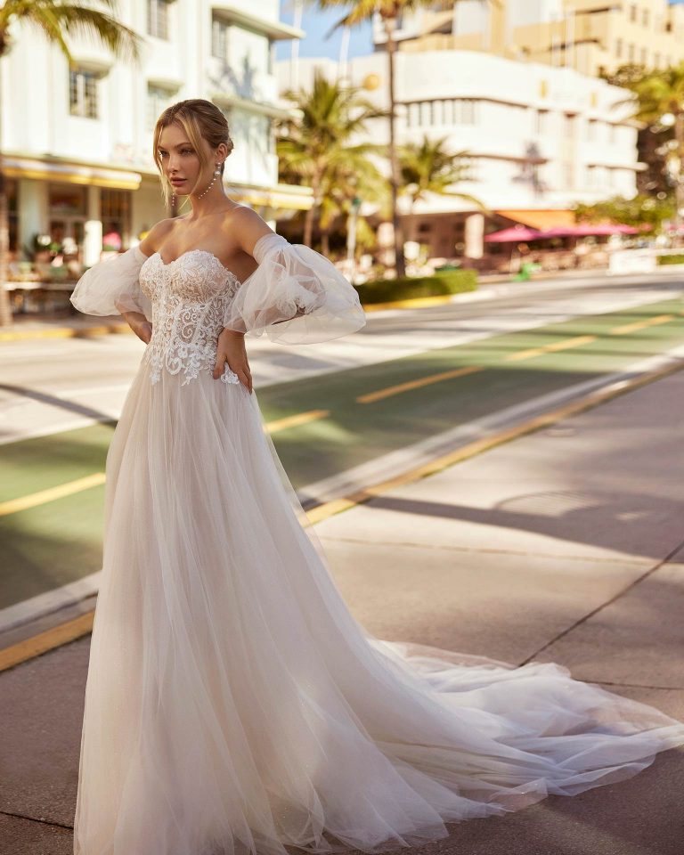 Romantic princess wedding dress, made with tulle and guipure. Featuring a sweetheart neckline, buttoned back, skirt with side slit and detachable sleeves. Delight in a delicate Luna Novias design. LUNA_NOVIAS.