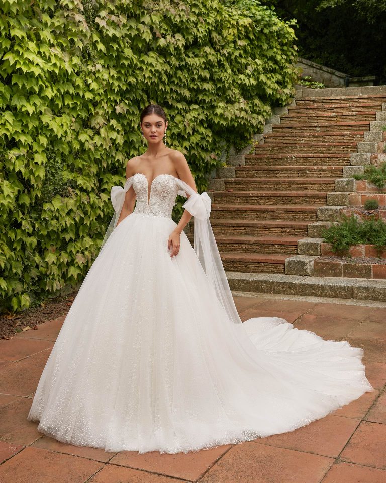 Romantic princess wedding dress, made with lace and beadwork. This dreamy Luna Studio design will draw you in, with its tulle skirt, plunging neckline, buttoned back and detachable straps. LUNA_NOVIAS.