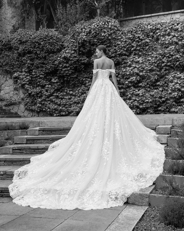 Romantic princess wedding dress, crafted in lace and beadwork. Featuring a plunging neckline, corset back and draped straps, this exclusive Luna Studio design is made to make you shine. LUNA_NOVIAS.