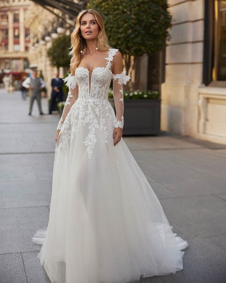 Vestido de novia largo de estilo bohemio, confeccionado en tul combinado con encaje y pedrería. Luce un escote corazón, una espalda cerrada, mangas extraíbles y tirantes. Un delicado modelo Luna Novias. LUNA_NOVIAS.