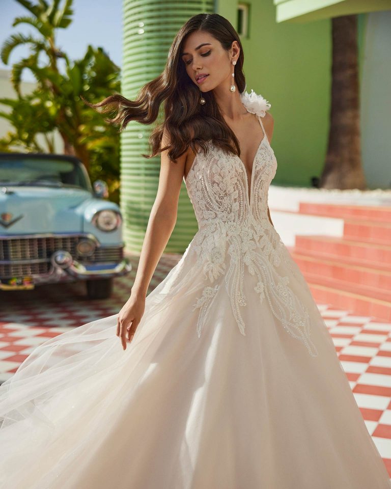 Vestido de novia largo de corte volumen. Tul Glitter, escote pico, tirantes con flores y espalda con tira de pedrería. LUNA_NOVIAS.