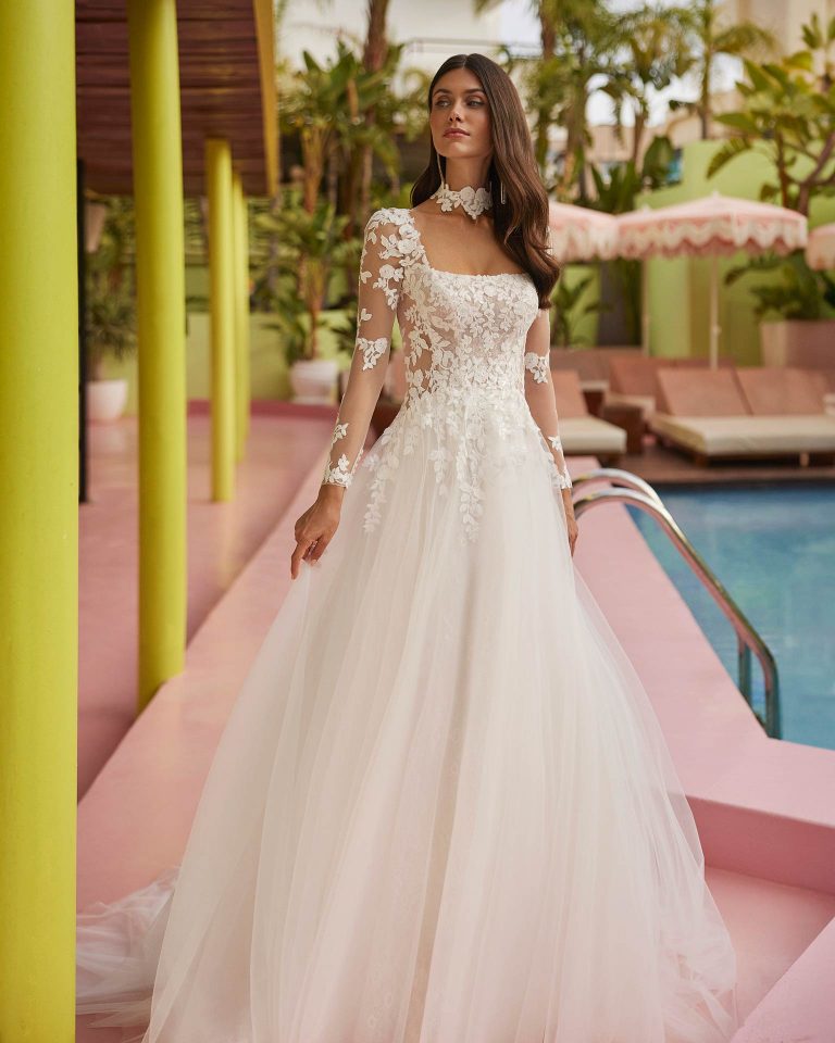 Vestido de novia largo de corte volumen. Encaje y pedrería, escote cuadrado, mangas extraíbles, espalda con abertura redonda y choker. LUNA_NOVIAS.
