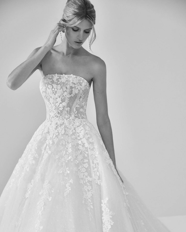 Vestido de novia largo de dos piezas con corte volumen. Encaje y pedrería, escote palabra de honor y espalda con cremallera con chaqueta. LUNA_NOVIAS.