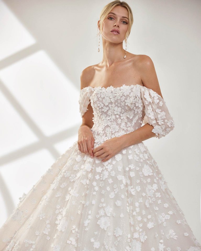 estido de novia largo de corte volumen. Tul glitter, escote palabra de honor, tirantes extraíbles y espalda descubierta. LUNA_NOVIAS.