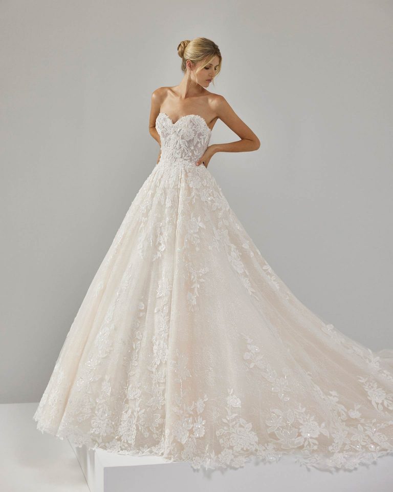 Vestido de novia largo de dos piezas con corte volumen. Encaje y pedrería, escote corazón y espalda descubierta con chaqueta. LUNA_NOVIAS.