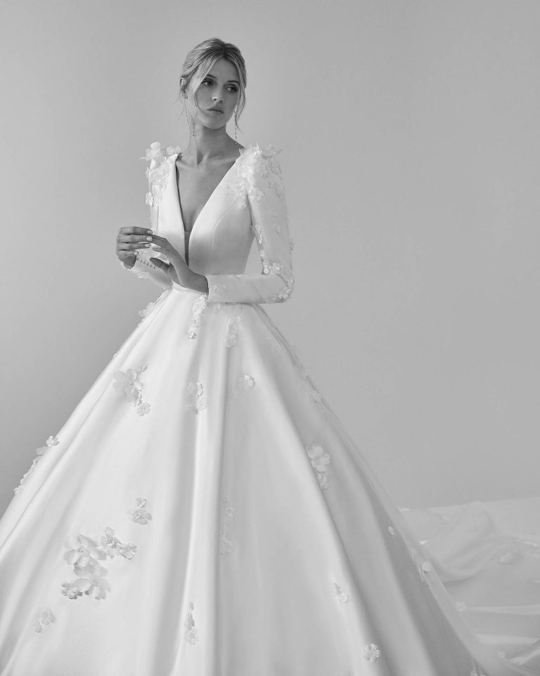 Vestido de novia largo de corte volumen. Raso, escote profundo, manga larga y espalda escotada. LUNA_NOVIAS.
