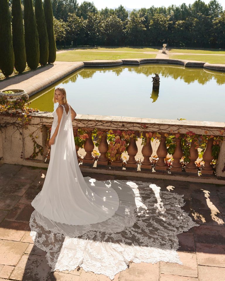 Mermaid wedding dress with deep neckline and open back. Lace bodice with cut-out detail on the back, beaded straps, bi-elastic crepe skirt and georgette layer with lace. LUNA_NOVIAS.