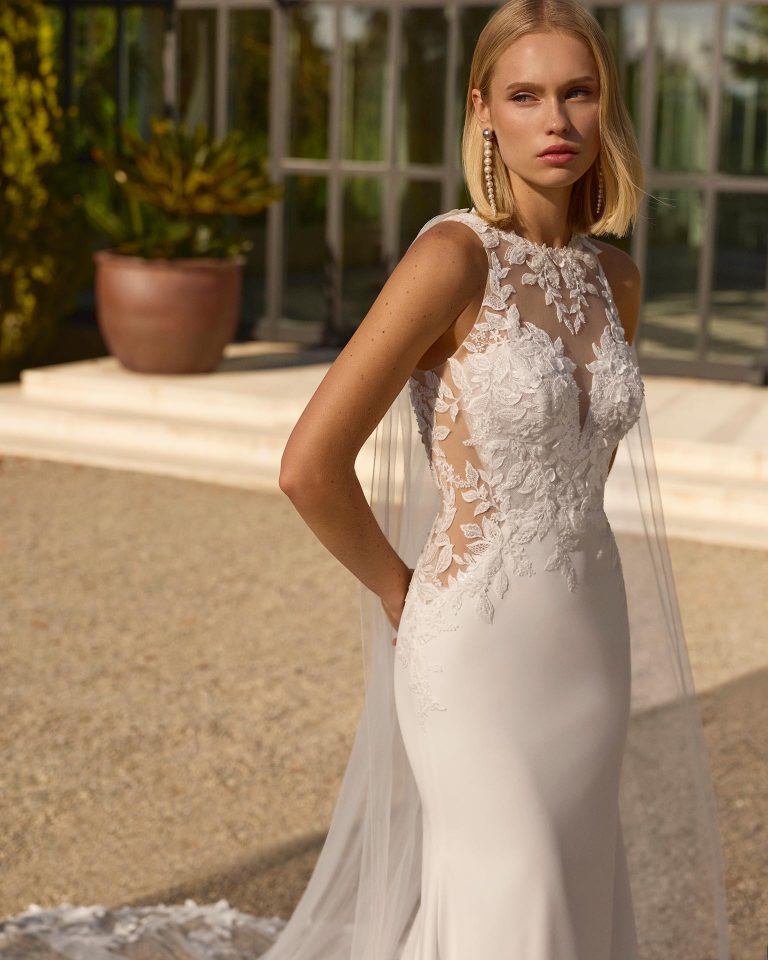 Two-piece mermaid silhouette wedding dress. Illusion neckline and back with button closure. Beaded lace bodice with lining, plain stretch crepe skirt. Includes cape LUNA_NOVIAS.