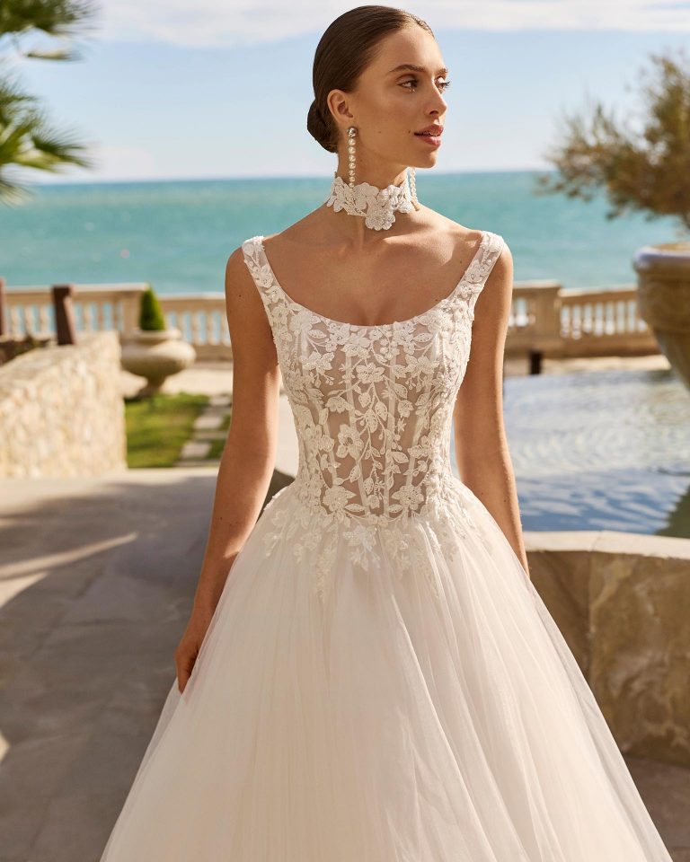 A-line wedding dress with round neckline, straps, lace bodice with beading, tulle skirt with appliques, round back opening and corset closure LUNA_NOVIAS.