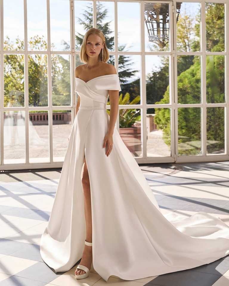 A-line wedding dress in mikado with off-shoulder neckline, off-shoulder sleeves, beading on bodice and skirt with front slit LUNA_NOVIAS.