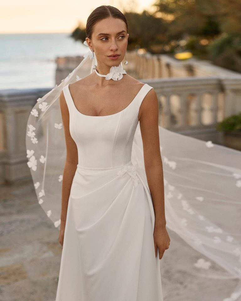 Wedding dress in mikado with A-line silhouette, round neckline, straps, round back, skirt with front slit, appliqués and draping. LUNA_NOVIAS.