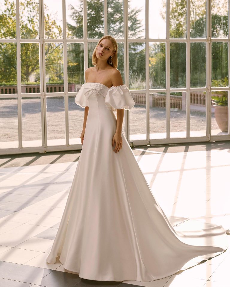 A-line wedding dress in matte mikado. Strapless sweetheart neckline, detachable puffed sleeves. Bodice with appliqués and beading, plain skirt. LUNA_NOVIAS.
