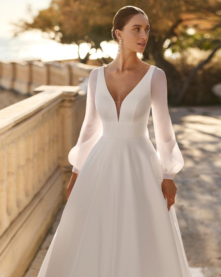 A-line wedding dress in mikado with bow, V-neckline and V-back. Long poet sleeves in chiffon. LUNA_NOVIAS.