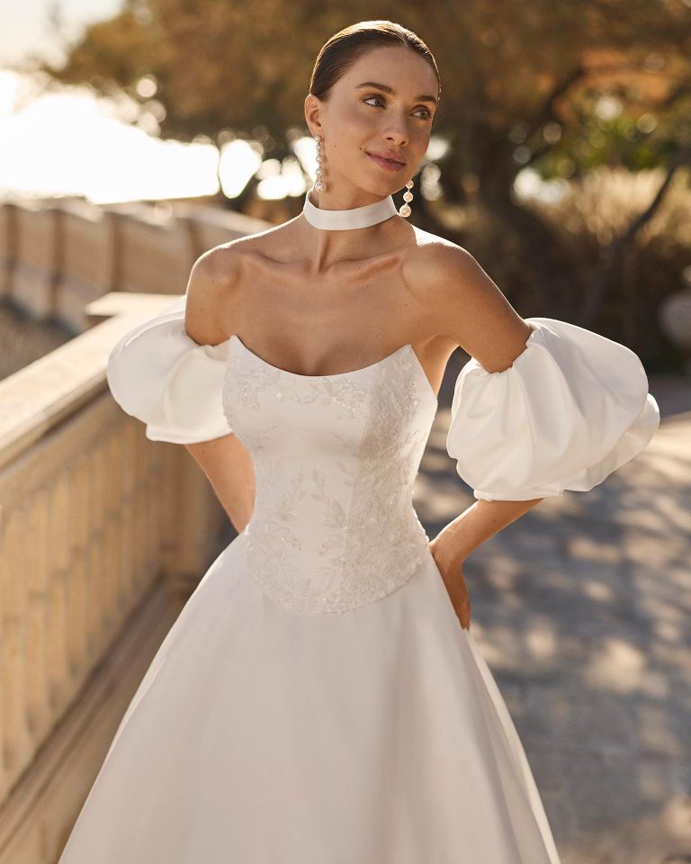 Two-piece wedding dress with A-line silhouette, sweetheart neckline, detachable puffed sleeves, beaded bodice, satin skirt and corset closure LUNA_NOVIAS.