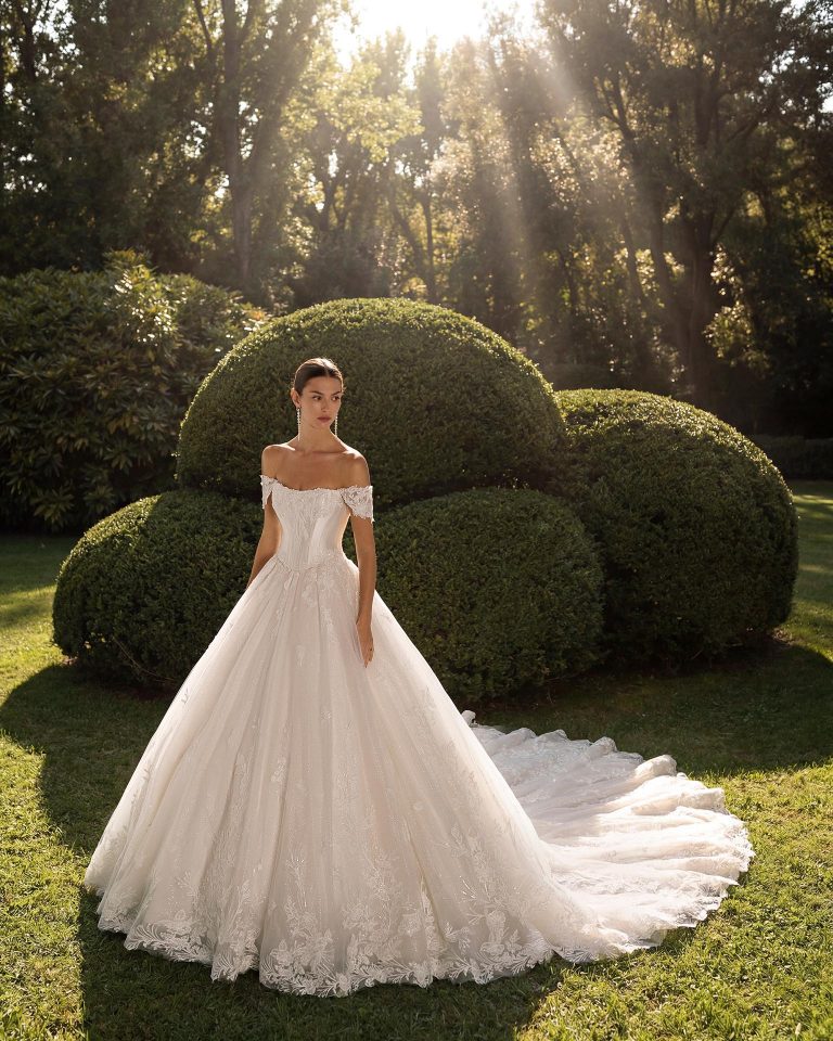 Two-piece bridal gown with sweetheart neckline and low-cut back. Lace bodice with removable short drop sleeve. Princess silhouette with glitter tulle skirt. Includes mikado corset. LUNA_NOVIAS.