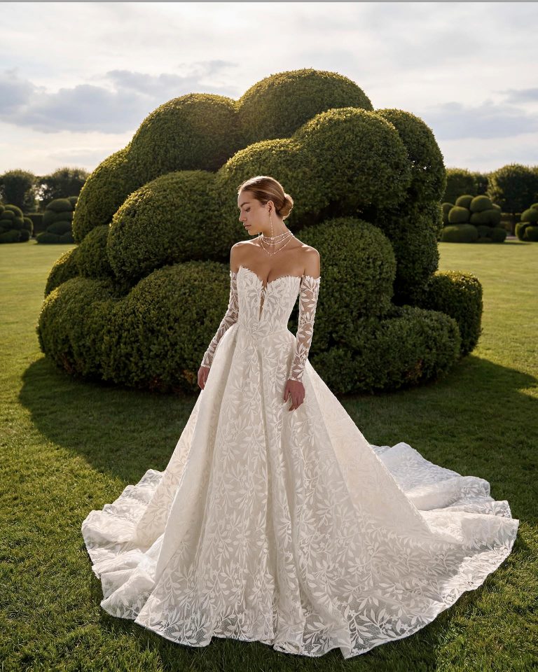 Princess wedding dress with sweetheart neckline and low-cut back. Lace bodice with rhinestone embellishments and detachable long lace sleeves. LUNA_NOVIAS.